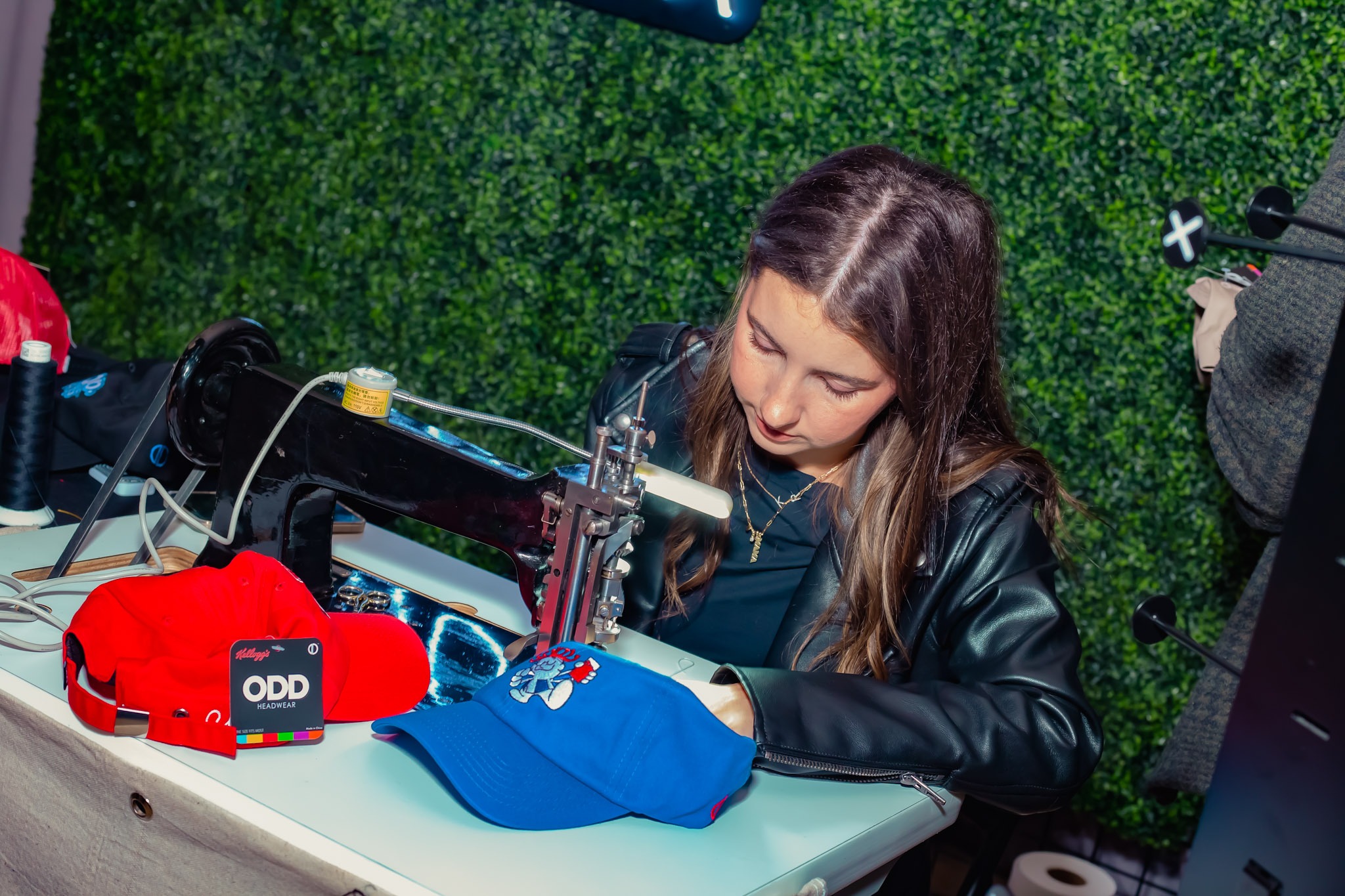 Live embroidery hat station creating personalized hats for guests at a corporate event planned by Pop, Sip & Celebrate Planning in Tampa Bay.